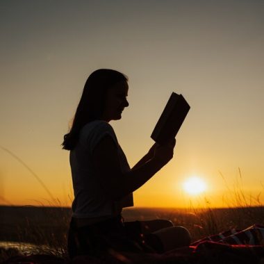 silhouette-jeune-fille-assez-belle-au-coucher-du-soleil-incroyable-assis-sommet-colline-riviere-fond-regardant-attentivement-livre